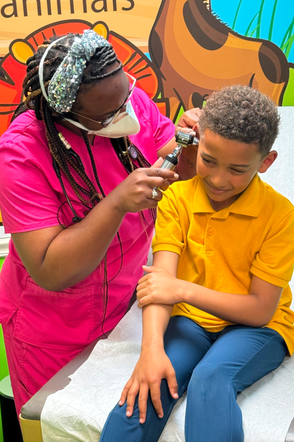 a doctor examining the kid's ear