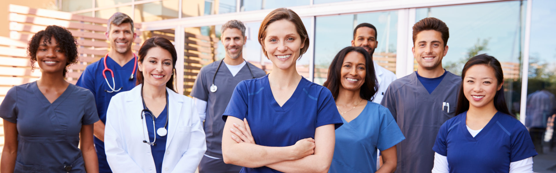 Team of healthcare workers with ID badges outside hospital